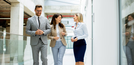 Young startup team have a discussion while walking in the office corridorの写真素材