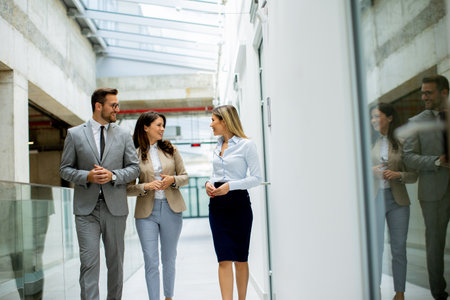 Young startup team have a discussion while walking in the office corridorの写真素材