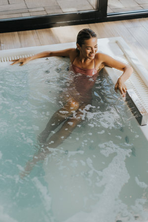 Pretty young woman relaxing in the indoor bubble poolの写真素材