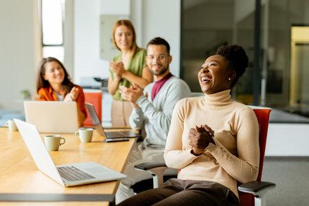 Cute Africam American woman with her young multiethnic startup team working at the modern officeの写真素材