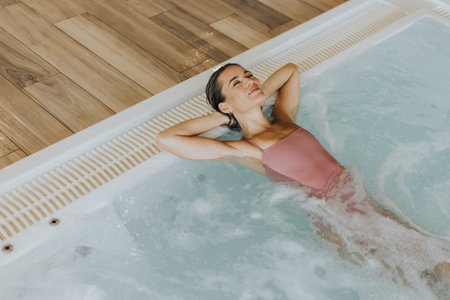 Pretty young woman relaxing in the indoor bubble poolの写真素材