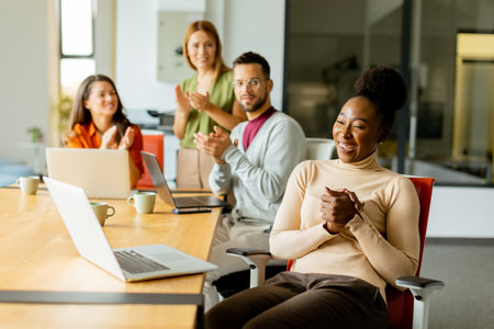 Cute Africam American woman with her young multiethnic startup team working at the modern officeの写真素材