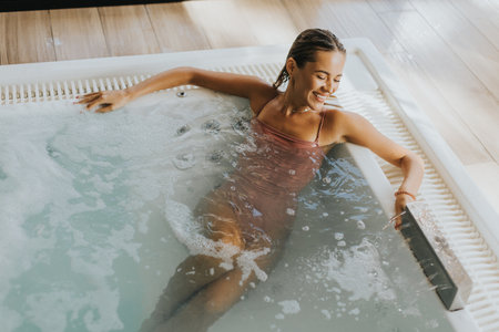 Pretty young woman relaxing in the indoor bubble poolの写真素材