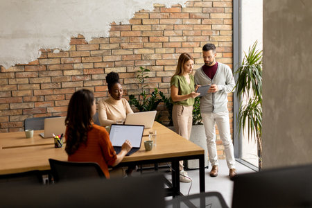 Young multiethnic startup team working by the brick wall in industrial style officeの写真素材