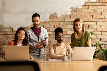 Young multiethnic startup team working by the brick wall in industrial style officeの写真素材
