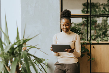 Young African American woman standing with digital tablet at the officeの写真素材
