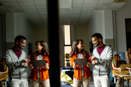 Young business couple standing with digital tablet in front of her team at the modern officeの写真素材