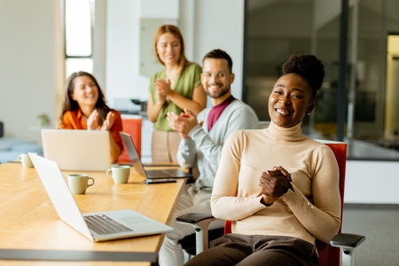Cute Africam American woman with her young multiethnic startup team working at the modern officeの写真素材