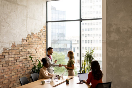 Young multiethnic startup team working by the brick wall in industrial style officeの写真素材