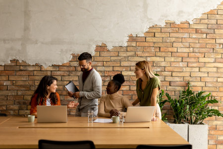 Young multiethnic startup team working by the brick wall in industrial style officeの写真素材