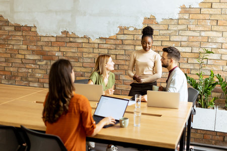 Young multiethnic startup team working by the brick wall in industrial style officeの写真素材
