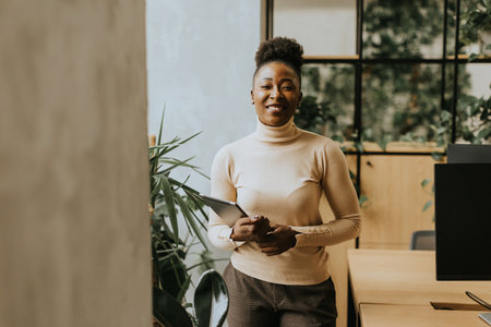 Young African American woman standing with digital tablet at the officeの写真素材