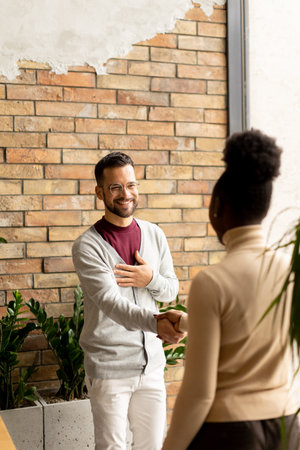 Handsome young multiethnic business couple handshaking in the modern officeの写真素材