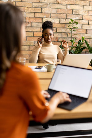 Two pretty young business women working in the modern officeの写真素材