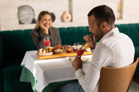 Young couple having a lunch and drinking fresh squeezed juice in the restaurant