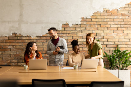Young multiethnic startup team working by the brick wall in industrial style officeの写真素材