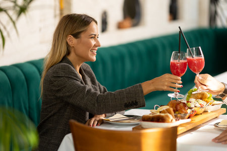Young couple having a lunch and drinking fresh squeezed juice in the restaurantの写真素材