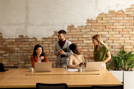 Young multiethnic startup team working by the brick wall in industrial style officeの写真素材