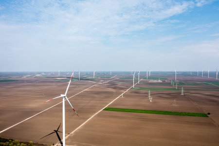 Row upon row of towering wind turbines dominate the landscape, harvesting energy as day breaksの写真素材