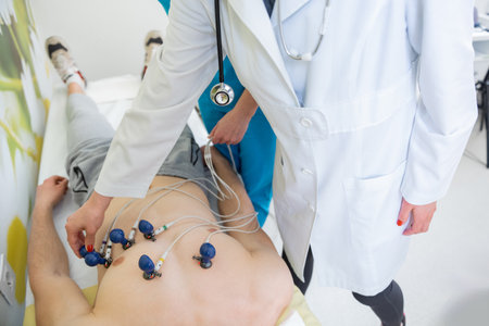 Skilled practitioner carefully attaches EKG electrodes to a patient for heart monitoringの写真素材