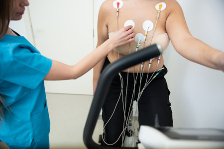 Obese young female is being monitored by a healthcare professional during a treadmill stress test.の写真素材