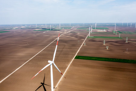 Row upon row of towering wind turbines dominate the landscape, harvesting energy as day breaksの写真素材