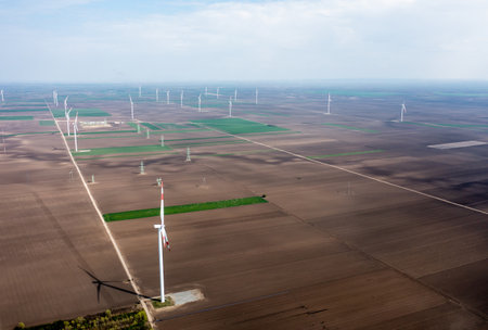 Row upon row of towering wind turbines dominate the landscape, harvesting energy as day breaksの写真素材