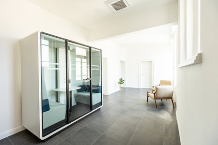 Contemporary office with large glass meeting room, minimalist furniture, and bright ambianceの写真素材