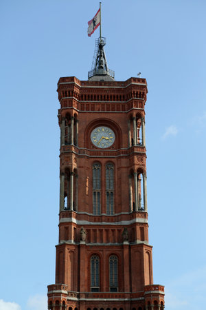 riking tower of Rotes Rathaus stands tall and proud against a clear blue sky in Berlin, Germany and inviting visitors to admire its intricate red brick design and historic significanceの写真素材