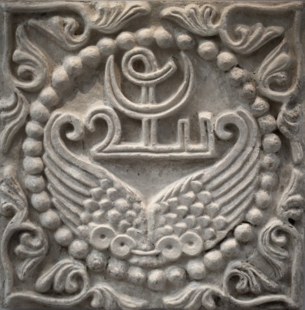 Stucco relief wall panel showcases the artistry of the 6th century Sasanian period of Mesopotamia, adorned with wings and a unique Pahlavi device encircled by elegant pearlsの写真素材