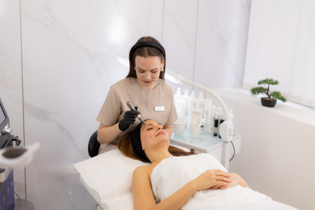 A skilled practitioner uses a microneedling mesotherapy device to revitalize a client's skin. The serene beauty clinic atmosphere complements the transformative treatment experience.の写真素材