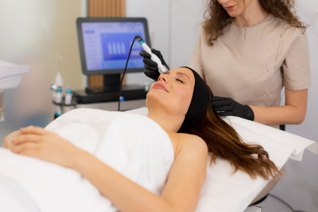 A skilled practitioner performs a revitalizing skincare treatment, focusing on pore cleansing and hydration for a relaxed client enjoying the healing ambiance of a wellness spa.の写真素材