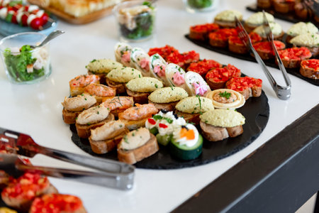 Colorful canapes arranged artfully on a sleek display invite guests to indulge at a vibrant...