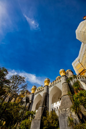 Breathtaking architecture of the National Palace of Pena, a Romanticist castle adorned with vibrant colors and unique details against a clear blue skyの写真素材