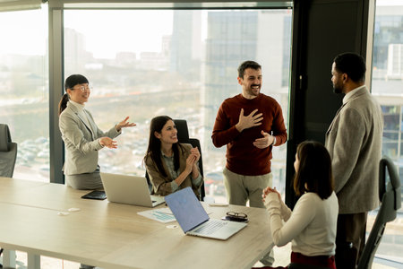 A diverse group of professionals engages in a dynamic brainstorming session around a conference...