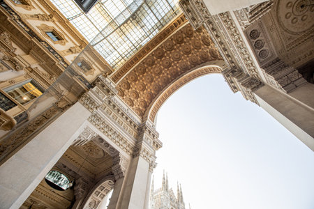 Visitors admire the stunning architecture of Galleria Vittorio Emanuele II under a bright sky, showcasing Milan's rich history and culture.の写真素材