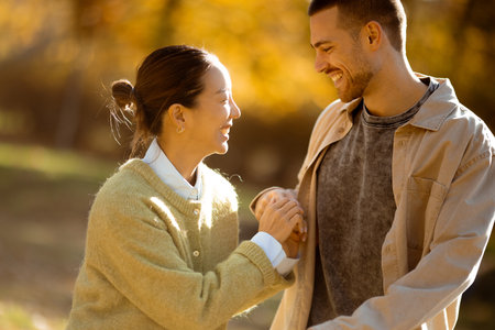 A warm scene unfolds as a Korean woman and Caucasian man share laughter, surrounded by colorful...