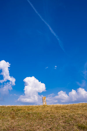 Tall tombstone stands in the necropolis near Nevesinje, under a bright blue sky.の写真素材