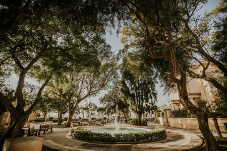 Visitors enjoy the tranquil beauty of Upper Barrakka Gardens, surrounded by lush greenery and calming fountains in Valletta, Malta.の写真素材