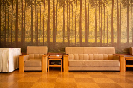 Pyongyang, North Korea - July 27, 2015: Cozy seating arrangements in the Koryo Hotel in Pyongyang  showcase a large mural of trees, adding warmth and tranquility to the space.のeditorial素材