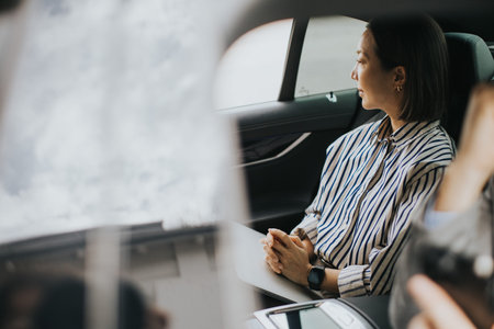 A Korean woman and a Caucasian man sit together in a car. The woman looks outside at the cloudy sky...