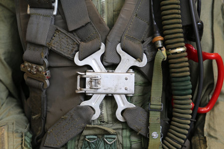 Detailed close-up of a military aircraft pilot safety harness, survival gear, oxygen hose, and flight suit, highlighting essential aviation equipment used during flight operations.