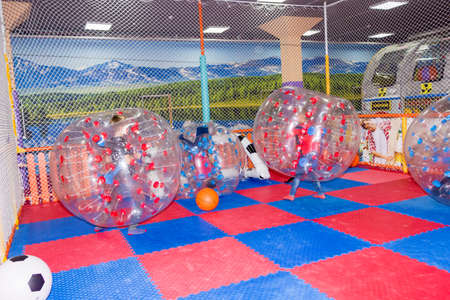 children, boys in the children's center play football while sitting in huge inflatable balls, hammer the ball into the goalの写真素材