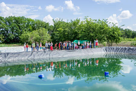 children in the field near an artificial reservoir on excursions, go through a questの写真素材