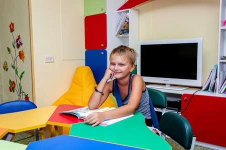 the boy in the children's center is engaged - reads, does assignmentsの写真素材