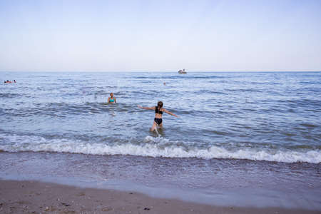 young girl running into the sea, by the surfの写真素材