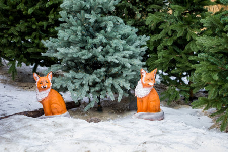 decorative red fox cubes in a winter park under the trees