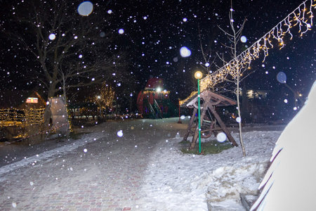 winter amusement park under the snow on a winter eveningの写真素材