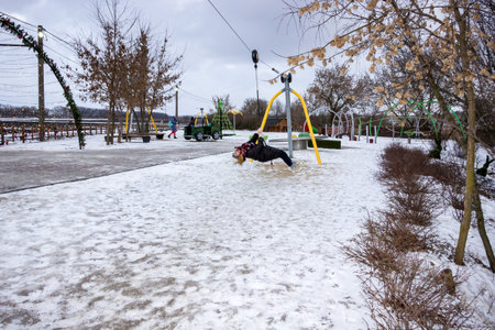 a girl rides a bungee in an amusement park in winterの写真素材