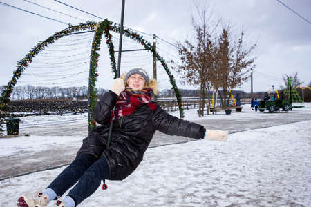 a girl rides a bungee in an amusement park in winterの写真素材